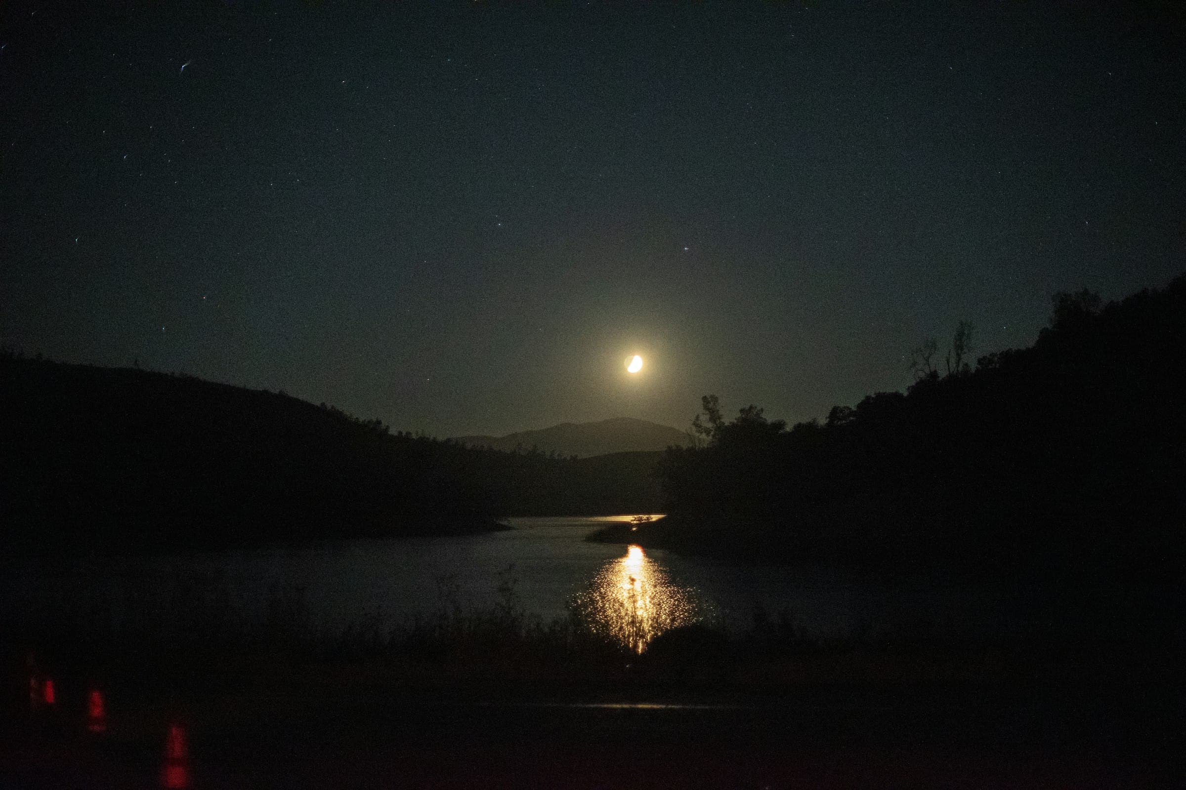 Moon rising over a lake — solunar fishing calendar